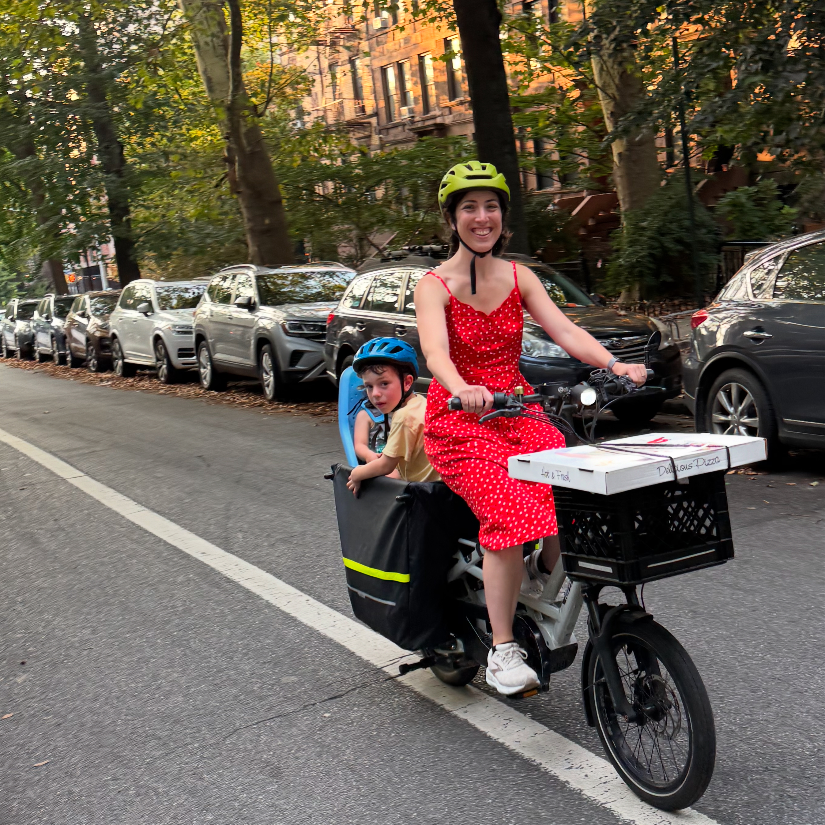 Rachel Bobbins riding her cargo bike with her son through Brooklyn